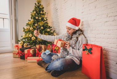 Mutlu kadın karantinada sanal Noel videosunu kutluyor ailesini ve arkadaşını akıllı cep telefonundan arıyor. Coronavirus karantina sosyal mesafesi nedeniyle sanal tatil buluşması çevrimiçi.