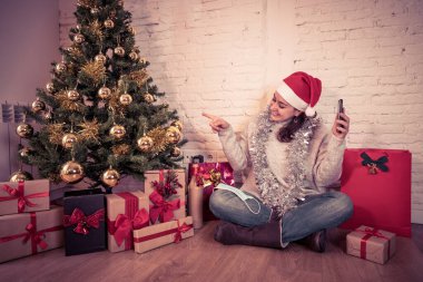 Mutlu kadın karantinada sanal Noel videosunu kutluyor ailesini ve arkadaşını akıllı cep telefonundan arıyor. Coronavirus karantina sosyal mesafesi nedeniyle sanal tatil buluşması çevrimiçi.