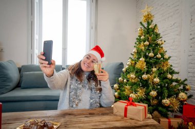 Mutlu kadın karantinada sanal Noel videosunu kutluyor ailesini ve arkadaşını akıllı cep telefonundan arıyor. Coronavirus karantina sosyal mesafesi nedeniyle sanal tatil buluşması çevrimiçi.