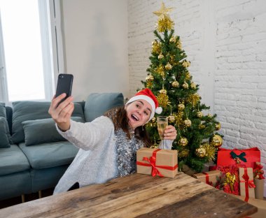 Mutlu kadın karantinada sanal Noel videosunu kutluyor ailesini ve arkadaşını akıllı cep telefonundan arıyor. Coronavirus karantina sosyal mesafesi nedeniyle sanal tatil buluşması çevrimiçi.