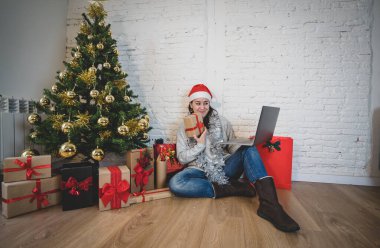 Mutlu kadın yalnız başına sanal Noel videosunu kutluyor ailesini ve arkadaşını arıyor. Koronavirüs karantinası, sosyal uzaklık ve yeni kısıtlamalar nedeniyle sanal tatil buluşması çevrimiçi.
