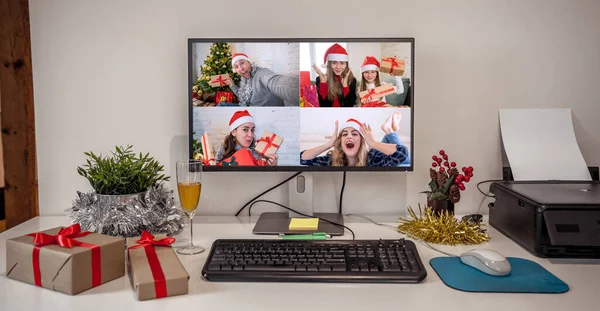 People on virtual call with family and friends exchanging gifts and celebrating virtual christmas online due to social distancing and coronavirus lockdown and quarantines. Image on computer screen.