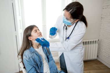Coronavirus enfeksiyonu için genç kızı test eden hemşire hızlı COVID-19 testi yaptırıyor. Doktor genizden örnek alarak, hastanın enfeksiyon kapıp kapmadığını analiz ediyor..