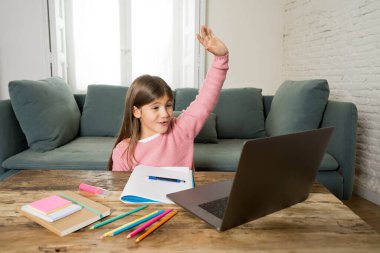 Bilgisayardaki Happy Liseli Kız son koronavirüs kilitlenmesi nedeniyle okullar kapalı kaldığı için evdeki internetteki sanal uzak bir sınıfta ders çalışıyor. COVID-19, eğitim, çocuklar ve E-öğrenim.