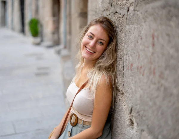 Açık havada, güzel sarı saçları ve şehvetli gülüşü olan çekici genç bir kadının portresi var. Doğal güzellik ve ışıkla poz veren kadın model. Gerçek insanlar, güzellik, moda ve yaşam tarzı.