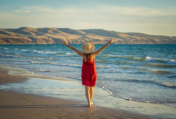 Kırmızı Elbiseli Mutlu Olgun Bir Kadın Sahilde Özgürlüğün Tadını Çıkarıyor — Stok fotoğraf