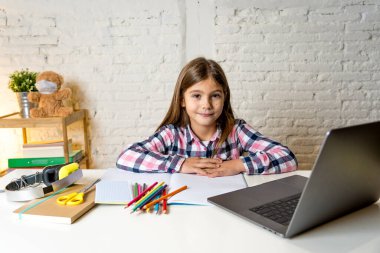Bilgisayardaki Happy Liseli Kız son koronavirüs kilitlenmesi nedeniyle okullar kapalı kaldığı için evdeki internetteki sanal uzak bir sınıfta ders çalışıyor. COVID-19, eğitim, çocuklar ve E-öğrenim.