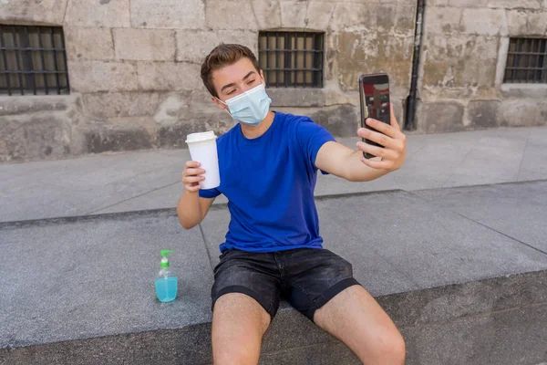 Ung Man Stadens Gata Med Skyddande Mask Med Hjälp Handdesinfektionsmedel — Stockfoto