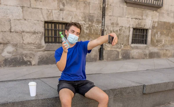 Ung Man Stadens Gata Med Skyddande Mask Med Hjälp Handdesinfektionsmedel — Stockfoto