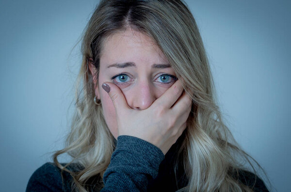 Sad depressed and worried woman feeling upset, distressed and sick. Young lonely woman crying suffering from depression due to coronavirus outbreak. Mental health and Covid-19.