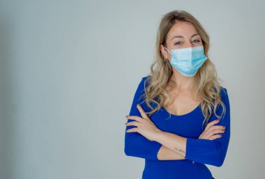 Tarafsız arka planda izole edilmiş koruyucu tıbbi maske takan çekici genç bir kadının yakın plan portresi. Milenyum dişisi, Coronavirus 'un yayılmasına karşı yüz koruması altında, Covid-19..
