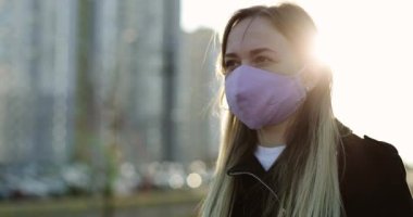 Günbatımında koruyucu maske takan genç bir kadının portresi.. 
