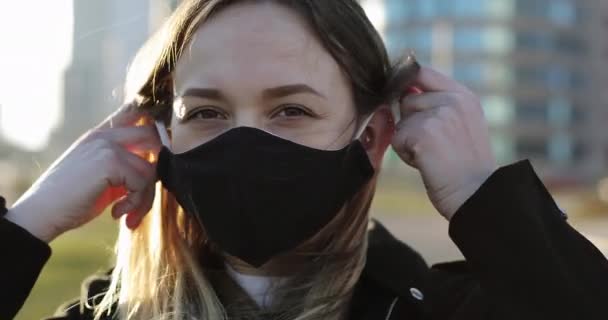 A young smiling woman takes off a medical mask. — Stock Video