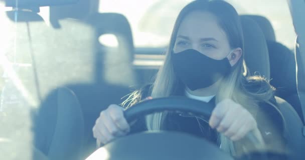 의료용 방호복을 입은 한 여자가 차를 운전하고 있다. — 비디오