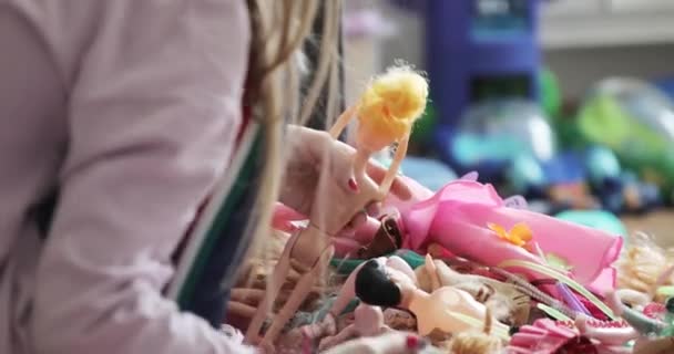 Het meisje speelt thuis met poppen. — Stockvideo