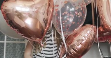 Balonların arkasında gülümseyen mutlu küçük kız.. 