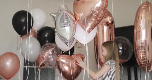 Sarışın bir kız balonların arkasında duruyor.. — Stok video