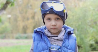 Sevimli küçük çocuk gülümser ve sınıfa parmağını gösterir..