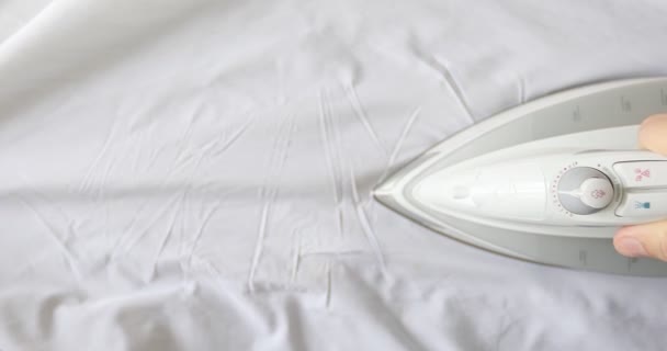 Mann bügelt weiße Kleidung mit Dampfbügeleisen auf Bügelbrett. — Stockvideo