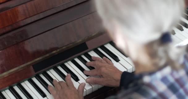 Mujer mayor con el pelo gris toca el piano. — Vídeos de Stock