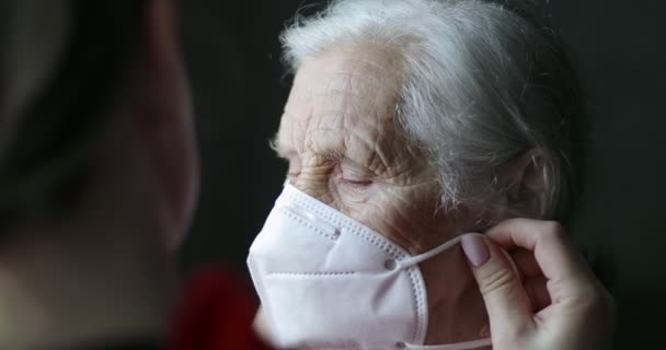 Wanita yang hadir mengenakan masker medis untuk nenek. — Stok Video