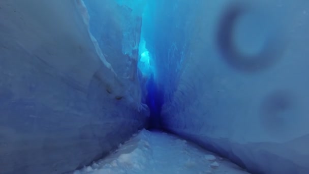 Blå isgrotta täckt med snö och översvämmad av ljus. — Stockvideo