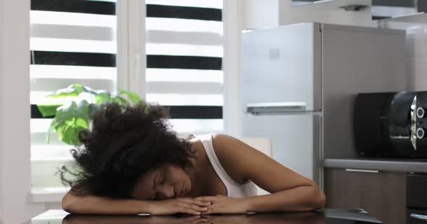 Mujer negra cansada dormida en la mesa de la cocina. — Vídeos de Stock