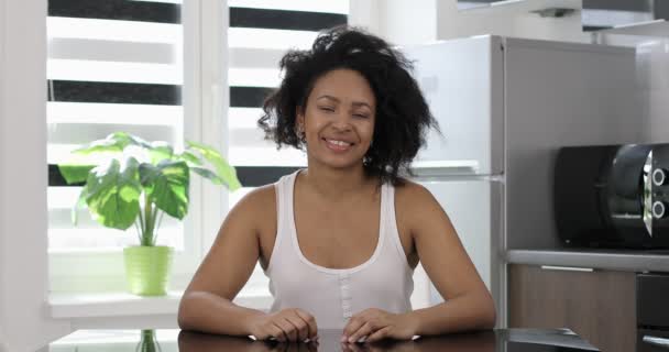 Happy stijlvolle Afro-Amerikaanse vrouw kijkt naar camera zitten. — Stockvideo