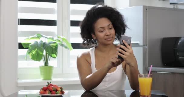 Relajada mujer afroamericana uso de teléfono inteligente viendo las redes sociales. — Vídeos de Stock