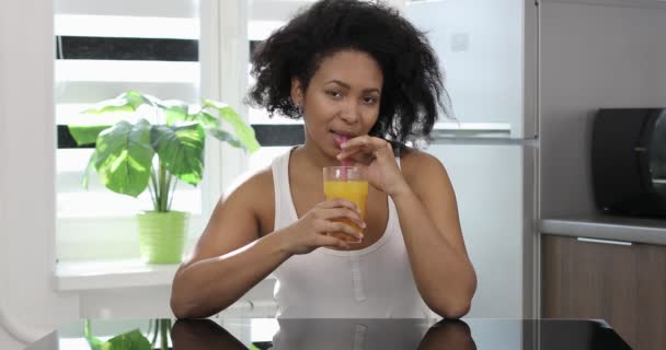 Felice razza mista donna in possesso di succo d'arancia e cercando di fotocamera. — Video Stock
