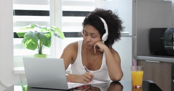 Yorgun Afro-Amerikalı iş kadını kulaklık takıyor. . — Stok video