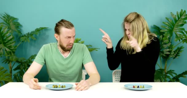 Жінка і чоловік їдять смачну і огидну їжу . — стокове відео