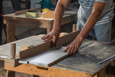 Bir marangoz, makine aletinin ahşap işçiliğinde çalışır. Marangoz, marangoz dükkanında marangozluk yapıyor..