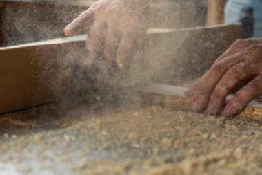 Bir marangoz, makine aletinin ahşap işçiliğinde çalışır. Marangoz, marangoz dükkanında marangozluk yapıyor..