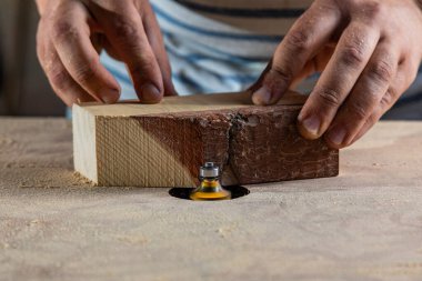 Bir marangoz, makine aletinin ahşap işçiliğinde çalışır. Marangoz, marangoz dükkanında marangozluk yapıyor..