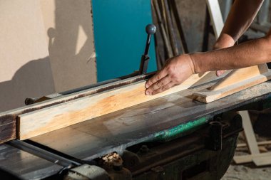 Bir marangoz, makine aletinin ahşap işçiliğinde çalışır. Marangoz, marangoz dükkanında marangozluk yapıyor..