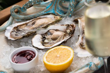 Sos, limon ve bir bardak şaraplı taze istiridye.