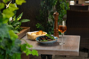 Kremalı soslu midye, kızarmış ekmek ve bir bardak şarap.