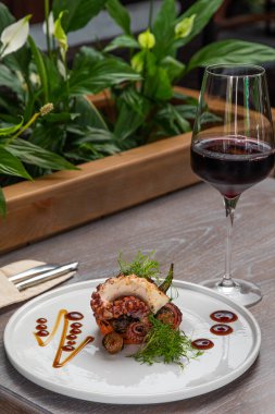 Bir bardak kırmızı şarapla ızgara ahtapot.