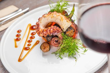 Bir bardak kırmızı şarapla ızgara ahtapot.