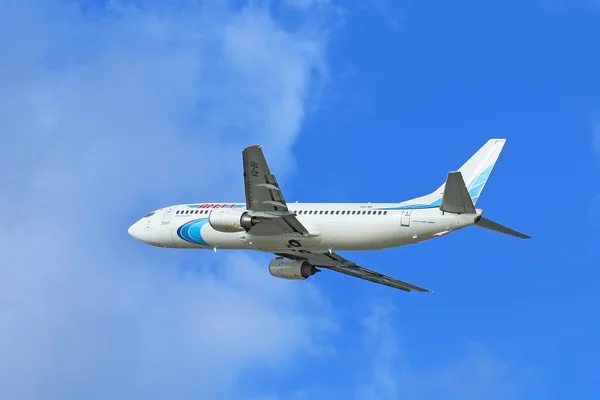 Letadlo Boeing 737-400 proti modré obloze a mraky — Stock fotografie