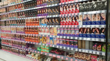 Nadym, RUSSIA-MAYIS 12, 2021: Kadınlar için saç boyama ürünleri içeren rafları depola