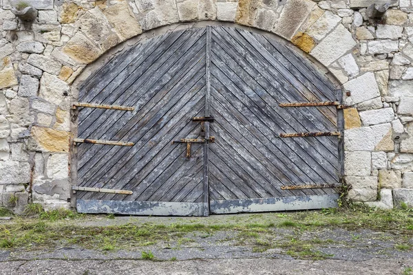 Antiguo muro de piedra y puerta de madera — Foto de Stock