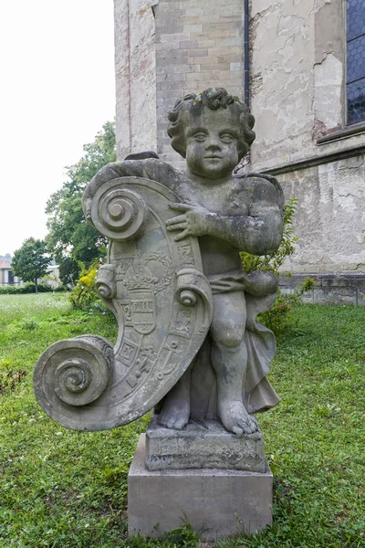 Alte Skulptur im Park neben der Kirche — Stockfoto