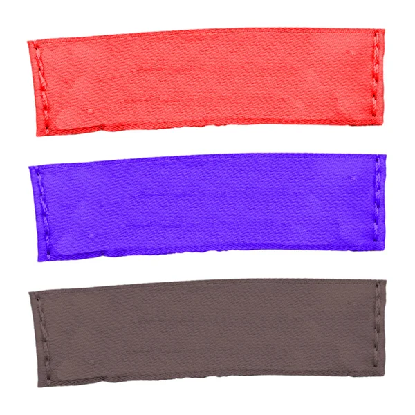 Três etiquetas de tecido de cor diferente isoladas em branco — Fotografia de Stock