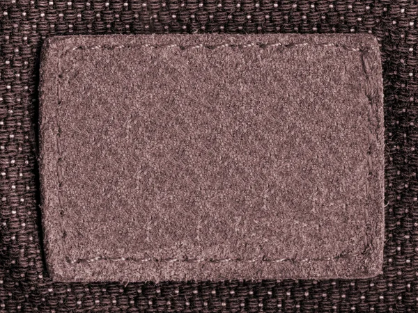 old blank brown label on textile background