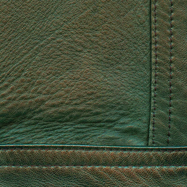 Old green leather background decorated with seams — Stock Photo, Image