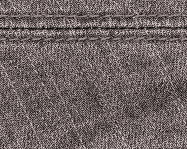 Brauner Jeanshintergrund mit Naht verziert. — Stockfoto