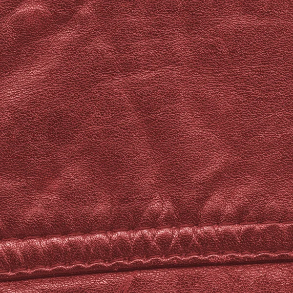 Red leather texture decorated with seam — Stock Photo, Image