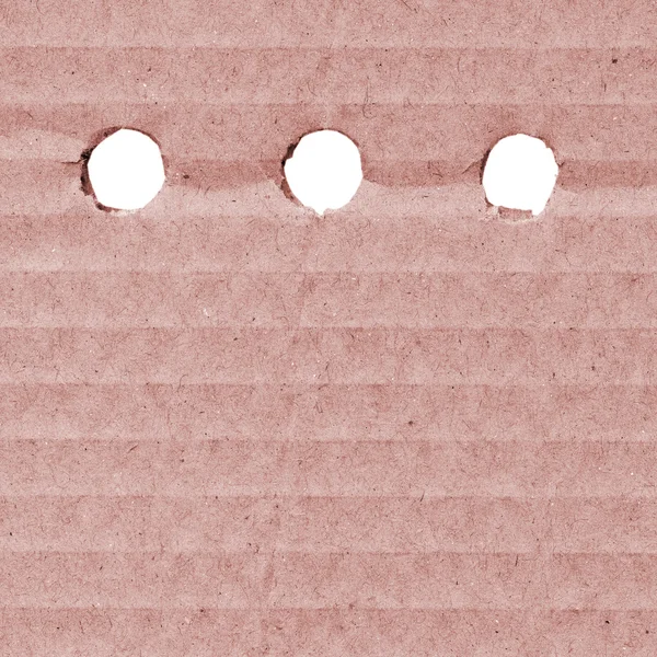 Delikleri ile kırmızı karton — Stok fotoğraf
